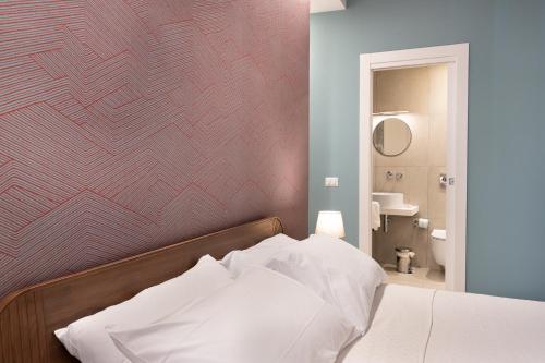 a bedroom with a bed with a red wall at Sant'Agostino Luxury Apartments in Catania