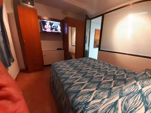 a hotel room with a bed and a flat screen tv at La SUCURSAL in Cazalegas