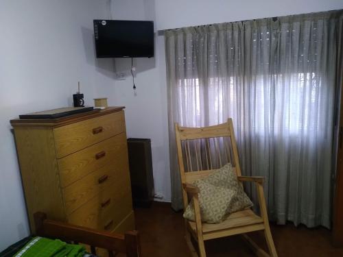 1 dormitorio con vestidor, silla y TV en DEPARTAMENTO EN LOMA HERMOSA 2 en Loma Hermosa