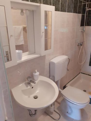 łazienka z białą umywalką i toaletą w obiekcie Apartments Verica w mieście Pag