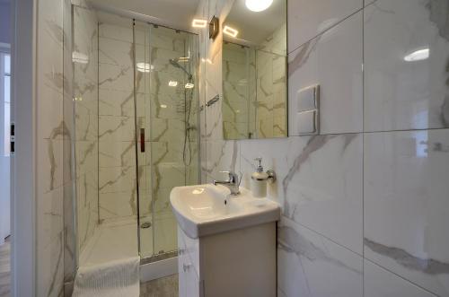a white bathroom with a sink and a shower at Mega widok in Szklarska Poręba