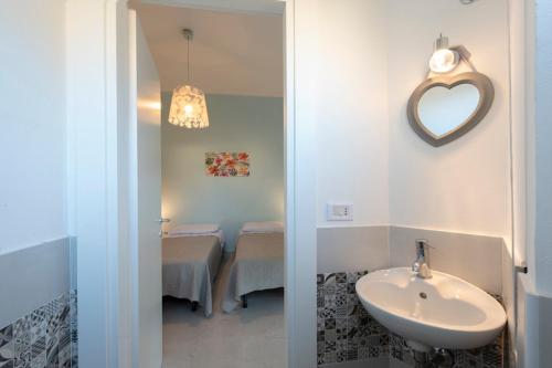 Pokój obejmuje łazienkę z umywalką i lustrem. w obiekcie Casa Bella - 3 Baths - Walk to Ortigia w Syrakuzach