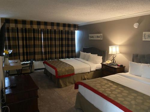 a hotel room with two beds and a desk at Ramada by Wyndham Albuquerque Midtown in Albuquerque