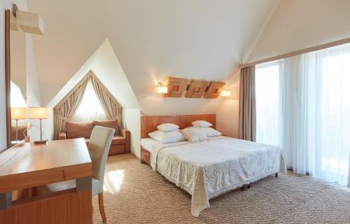 a bedroom with a bed and a desk and a desk at Hotel Zbójnicówka in Bukowina Tatrzańska