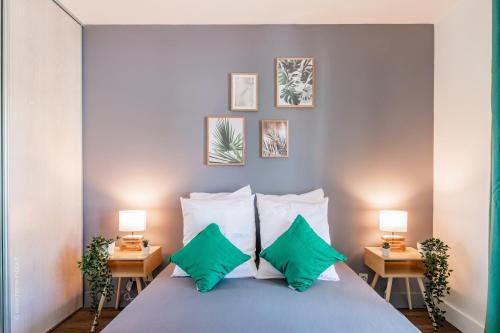 - une chambre avec un lit et des oreillers verts dans l'établissement Little Big Vacations - 10min Disneyland, à Bussy-Saint-Georges