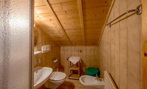 een badkamer met een wastafel, een toilet en een wastafel bij Krüglwirt in San Lorenzo di Sebato