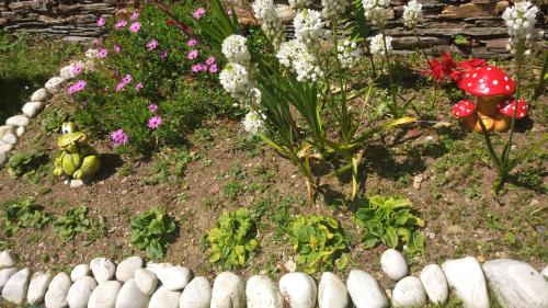 a garden with flowers and a stone fence at Vivienda de Uso Turístico Carballo Blanco 2 in Barral