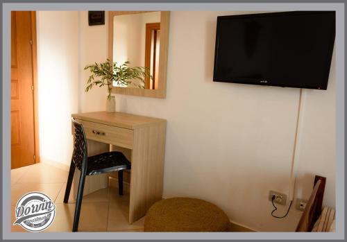 a room with a desk and a television on a wall at Dorvin Apartments in Dhërmi