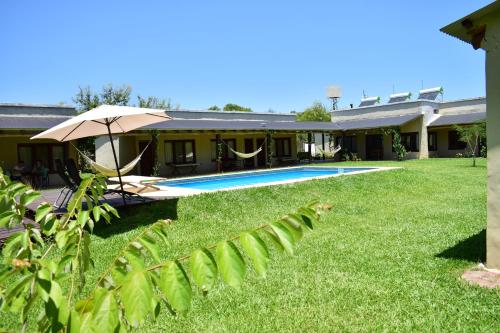 una casa con un patio con piscina en Arandu ecolodge en Colonia Carlos Pellegrini