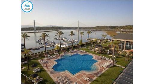 a large swimming pool next to a river with a bridge at BOCA DO RIO - Apartamento 109 in Estômbar
