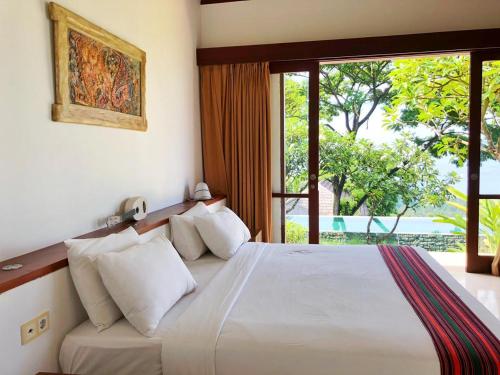 a bedroom with a bed with a large window at Villa Vanna - Lombok in Senggigi 