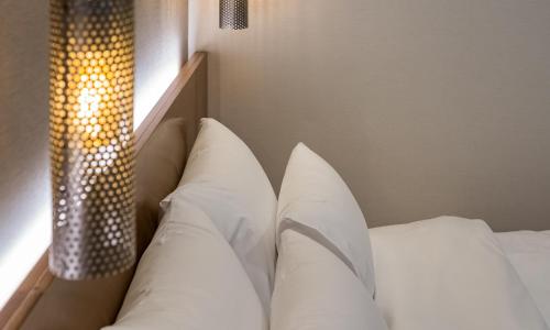 a bed with white pillows next to a window at Stubborn Hotel in Geoje 