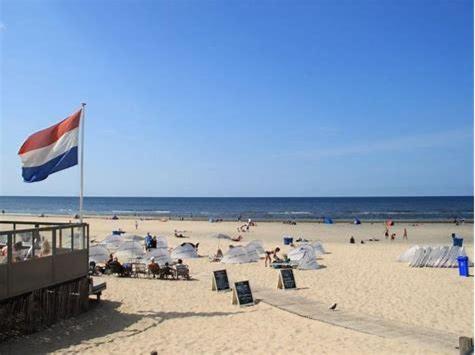 a group of people on a beach with a flag at Boutique zomerhuis De groene Parel in Schoorl