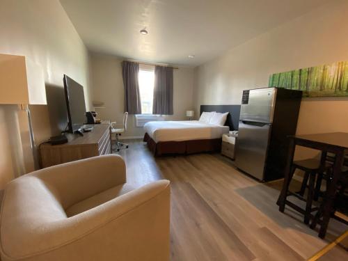una camera d'albergo con letto e divano di Chalet Continental Motel a Valemount