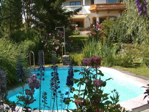 einen Pool in einem Garten mit Blumen in der Unterkunft Landhotel Eva in Kirchberg in Tirol