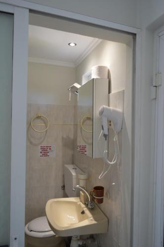 a bathroom with a sink and a toilet and a mirror at Billy's Rooms in Moraitika