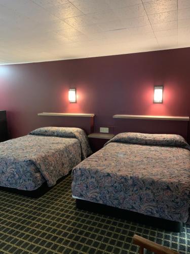 2 Betten in einem Hotelzimmer mit roten Wänden in der Unterkunft Boone trail inn in Middlesboro