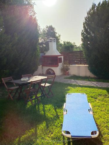 a picnic table and a grill in a yard at Kalamaki Court Villas in Kalamaki