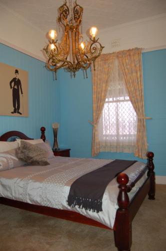 a bedroom with a bed with a chandelier and a window at Deepwater Bank BnB in Deepwater