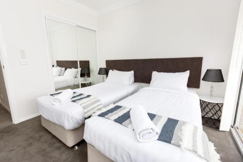 1 dormitorio con 2 camas y sofá en Wagga Apartments #3, en Wagga Wagga