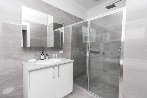 y baño con lavabo blanco y ducha. en Wagga Apartments #3, en Wagga Wagga