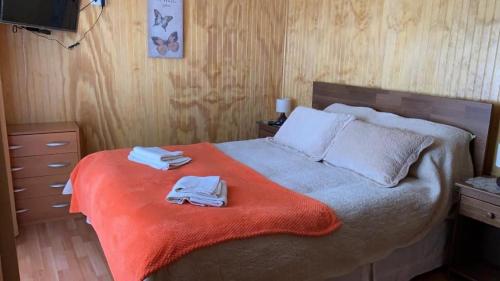 una camera da letto con un letto e due asciugamani di Hostal Patagonia Marmol a Coihaique