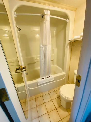 a bathroom with a shower and a toilet at Harrisonville Inn & Suites in Harrisonville