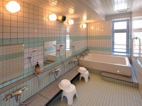 a bathroom with a tub and a toilet and a sink at Kumagaya Royal Hotel Suzuki in Kumagaya
