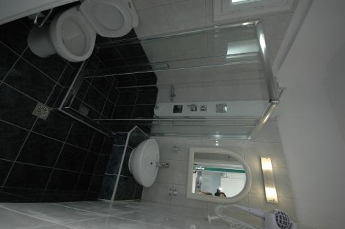 a bathroom with a mirror and a sink with a person in it at Hotel Anixis Resort in Naxos Chora