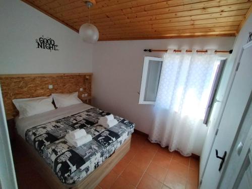 a bedroom with a bed and a window at SigmaApartment in Zambujeira do Mar