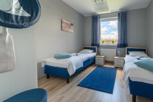a bedroom with two beds and a window at Nautical Sea Apartment in Gdynia