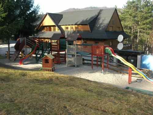 a playground in front of a house with a building at Drevenica pod smrekom in Terchová