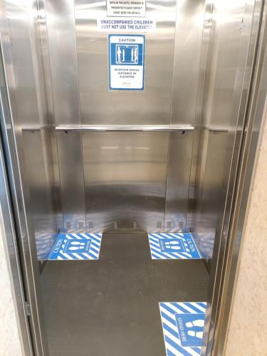 a metal elevator with blue and white signs on the floor at Fortune Inn Sree Kanya, Visakhapatnam - Member ITC Hotels' Group in Visakhapatnam