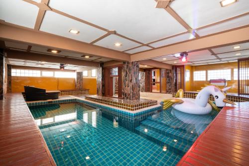 a swimming pool with a swan and an inflatable at Angel Pool Villa Phuket - SHA Extra Plus in Phuket Town
