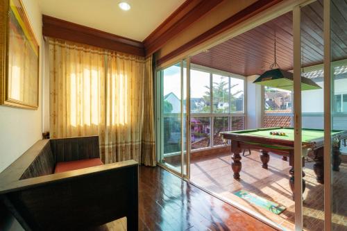 a living room with a pool table and a window at Angel Pool Villa Phuket - SHA Extra Plus in Phuket Town