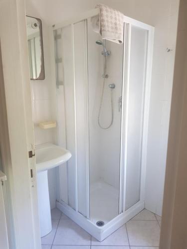 een witte badkamer met een douche en een wastafel bij Cavo Beach 4 in Cavo
