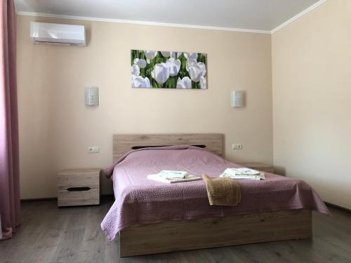 a bedroom with a bed with a purple blanket at Apartments IRIS in Chornomorsk