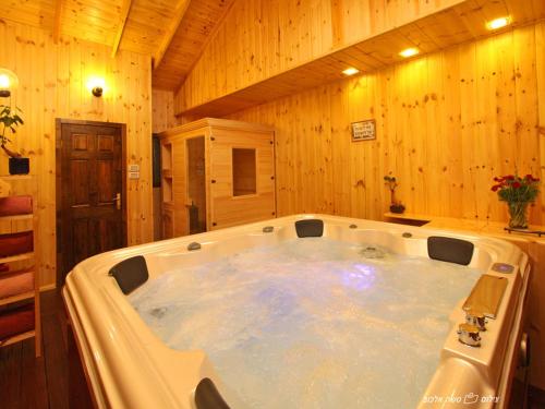 a large bath tub in a room with wooden walls at Suites & Spa Galilee in Qiryat Shemona