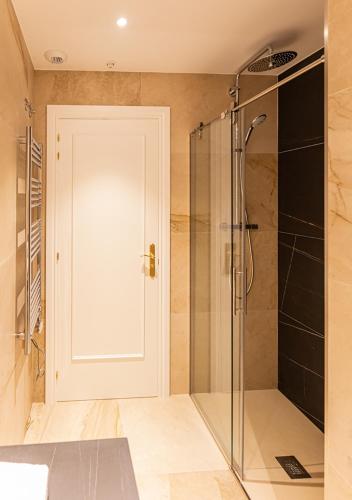 a bathroom with a shower and a glass door at Torre de Briñas Private Resort in Briñas