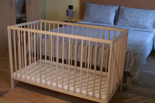 - un lit bébé dans une chambre à côté d'un lit dans l'établissement Ababo Affittacamere, à Quattro Castella