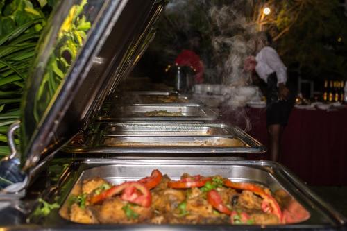a row of trays of food in a restaurant at Imperial Heights Hotel, Entebbe in Entebbe