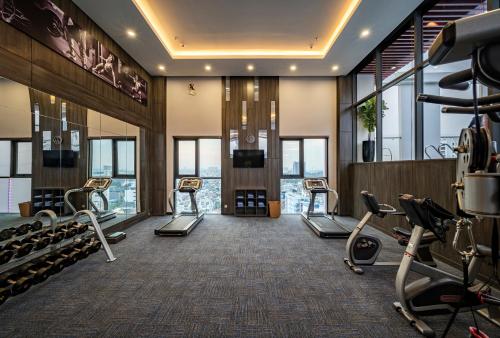a gym with cardio equipment in a building with windows at Muong Thanh Luxury Saigon Hotel in Ho Chi Minh City