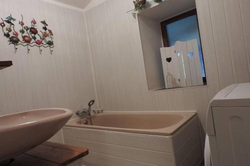 ein Badezimmer mit einer Badewanne, einem Waschbecken und einem Spiegel in der Unterkunft Cazabonne in Salles
