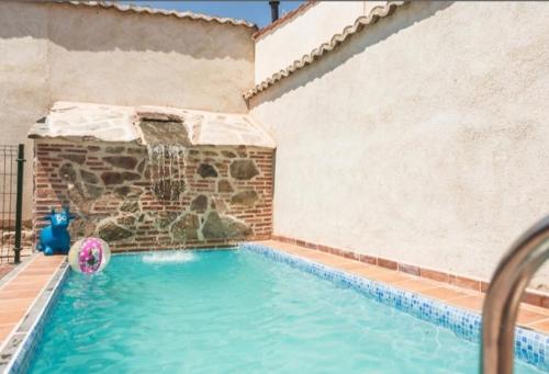 a swimming pool with a water fountain in a building at La Casa de los Dos Rubios in Nava de la Asunción