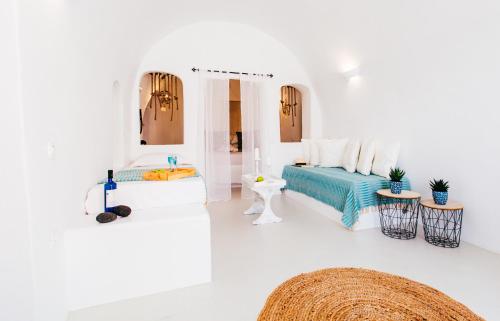 a white room with a bed and a mirror at Blessed Blue Boutique Cave Suite in Oia