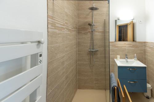ein Bad mit einer Dusche und einem Waschbecken in der Unterkunft le chalet in Airaines