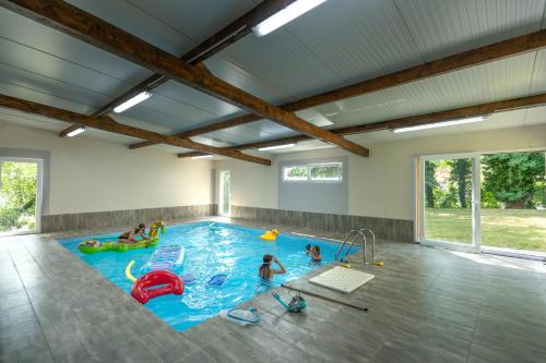 um grupo de pessoas numa piscina interior em le chalet em Airaines