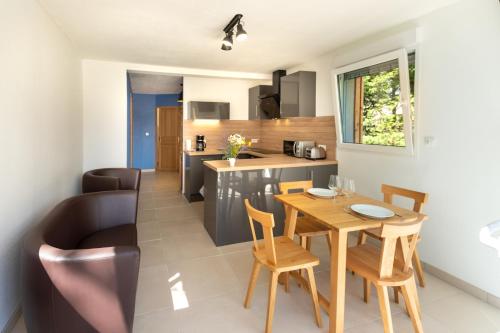 cocina y comedor con mesa y sillas en le chalet, en Airaines