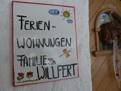 a sign on a building with a sign for a gardenwomen female united at Gästehaus Willfert in Reit im Winkl