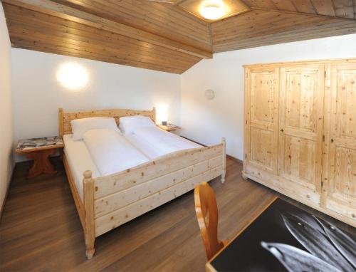 um quarto com uma cama e um tecto de madeira em Chalet Gloria - Doppel- und Mehrbettzimmer em Bruck an der Grossglocknerstrasse